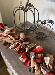 two pumpkins are sitting on a table with burlocks and ribbons around them