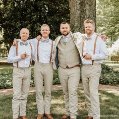 three men in tan pants and bow ties standing next to each other with their arms around one another