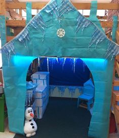 there is a frozen world play house with a snowman in the front and an ice man behind it