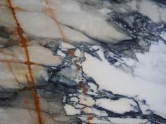 the marble is white and black with brown streaks on it's edges, as well as some orange lines