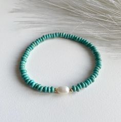 Add a pop of coastal charm to your style with this Turquoise Beaded Bracelet with Natural Pearl, featuring synthetic rondelle-shaped turquoise beads and a natural pearl bead at the centre, this bracelet captures the essence of beach-inspired fashion. The vibrant turquoise brings a carefree, summery vibe that pairs perfectly with casual looks or a breezy seaside escape, while the natural pearl bead adds an elegant touch that keeps it fresh and versatile. PS : Strung on a stretchable elastic band, Beach Trends, Turquoise Bead Bracelet, Coastal Charm, Stackable Bracelets, Natural Pearl, Beach Inspired, Turquoise Beads, Natural Pearls, Pearl Bracelet