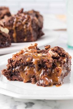 a piece of chocolate cake on a plate with caramel drizzle and nuts