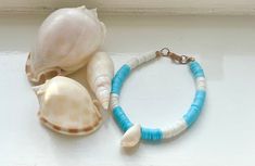 Beach blue is a bracelet with blue and white clay beads, a shell and a gold clasp to finish it off. It can be shipped across the world but there is free delivery anywhere in the UK. White Ocean-inspired Beaded Bracelets, Blue Shell Bohemian Bracelets, Bohemian Blue Shell Bracelets, Ocean-inspired Blue Beaded Bracelets For Beach, Bohemian Blue Shell Bracelet, Adjustable Blue Shell Top For Beach Style, Blue Beachy Shell For Vacation, Beachy Blue Shell For Vacation, Blue Shell Beaded Bracelets For Beach