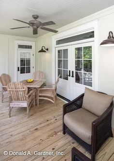 a patio with chairs, table and ceiling fan