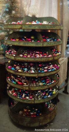 a rack filled with lots of different types of ornaments on top of a wooden table