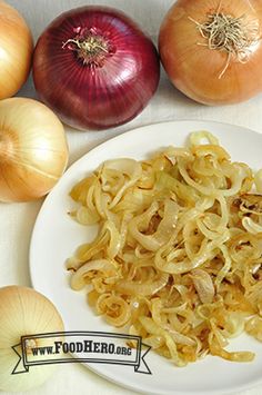 some onions are sitting on a white plate next to two red onions and one yellow onion