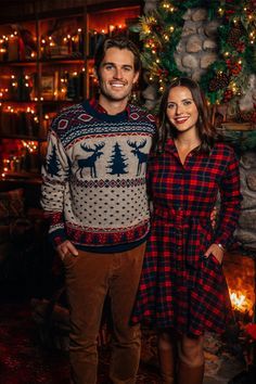 a man and woman standing in front of a christmas tree