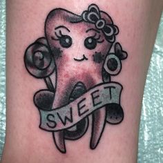 a tooth with a ribbon around it that says sweet on the side of someone's leg