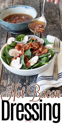 a bowl of hot bacon dressing on top of a wooden table next to a plate of salad