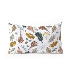 a white pillow with gold and green leaves on it