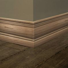 the corner of an empty room with wood flooring