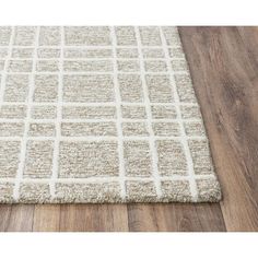 a white rug on top of a wooden floor with a wood floor in the background