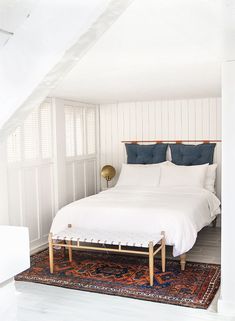 a bed sitting in the middle of a room on top of a rug