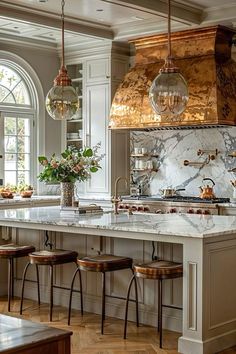 a kitchen with marble counter tops and wooden stools in front of an oven hood