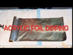 a roll of foil sitting on top of a white tablecloth covered in red lettering