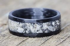 a black and white wedding ring with antler wood inlays on the outside