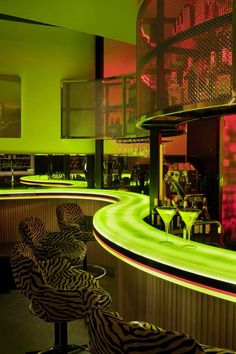 a bar with zebra chairs and neon lights