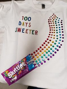 a t - shirt that says 100 days sweeter next to a candy bar