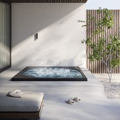 an outdoor jacuzzi tub in the middle of a patio with a small tree next to it