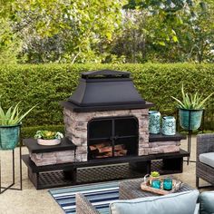 an outdoor fireplace surrounded by furniture and potted plants