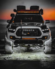 the front end of a toyota truck with its lights on