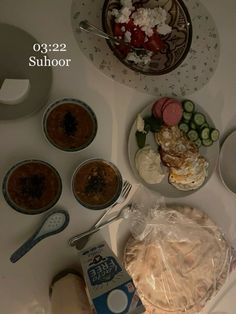 a table topped with plates and bowls filled with food next to a box of milk