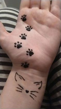 a person with a cat paw tattoo on their wrist