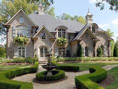 a large house with lots of hedges around it