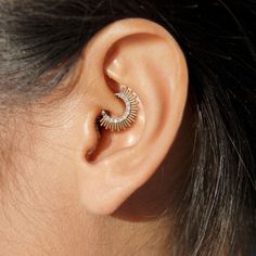 a woman's ear is shown with a small spiral design on the middle part