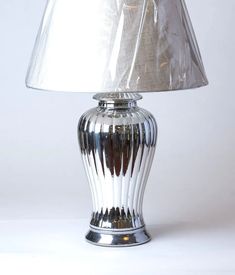 a silver lamp with a white shade on it