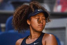 a female tennis player with her face painted orange