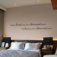 a bedroom with a large wall decal that says i have loved you for a thousand years