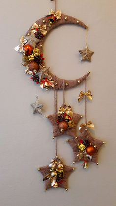 a crescent decorated with bells and ornaments hanging from it's side on a wall