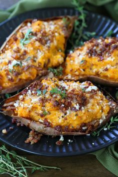 baked potato wedges with cheese and herbs on a black plate, ready to be eaten