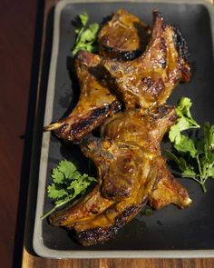 some meat is on a black plate with parsley