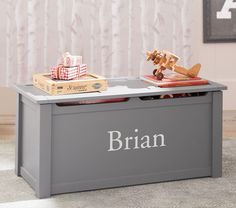 a toy chest with personalized items on top and a christmas tree in the background