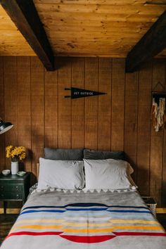 a bed in a room with wooden walls