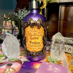 a purple bottle sitting on top of a table next to crystal rocks and other items