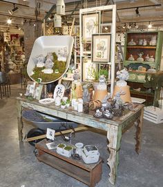 an old table with pictures and other items on it in a room filled with antiques