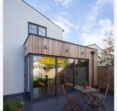 an outdoor patio area with wooden furniture and sliding glass doors