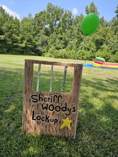 a wooden sign that says sheriff woody's lock up with a green balloon in the background