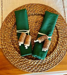 two green napkins on top of a wicker plate next to some corks