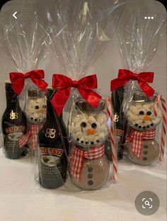 four bottles of booze and marshmallows are wrapped in cellophane to look like snowmen