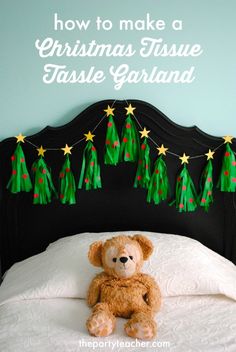 a teddy bear sitting on top of a bed in front of a christmas tree decoration