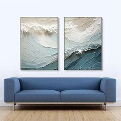 two paintings are hanging on the wall above a couch