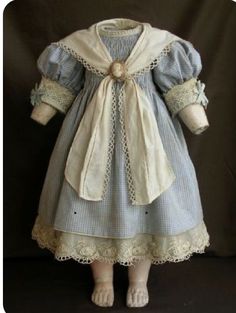 an old fashioned doll is dressed in blue and white