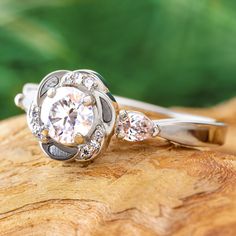 a diamond ring sitting on top of a piece of wood