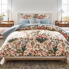 a bed with a floral comforter and pillows