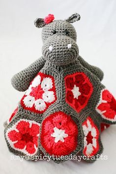 a crocheted hippo sitting on top of a white table next to a stuffed animal