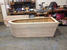 a large wooden box sitting on top of a floor next to a workbench